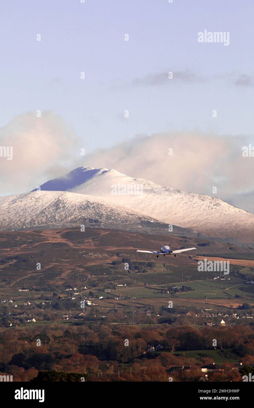 L'aereo leggero è decollato di recente dall'aeroporto di Caernarfon e si dirige verso la catena montuosa di Snowdonia Foto Stock