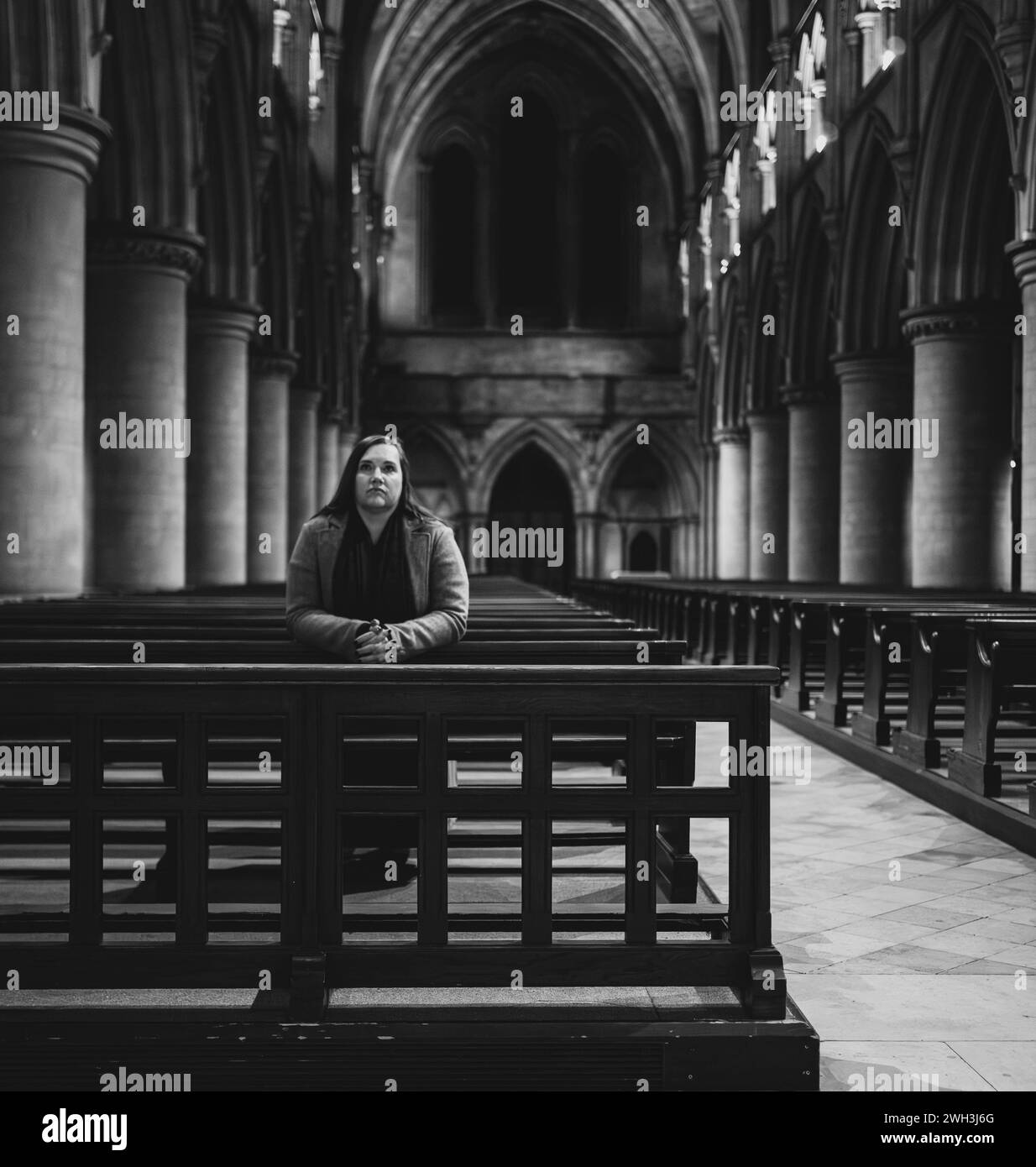 Donna che prega nella Cattedrale di San Giovanni Battista, Norwich. Foto Stock