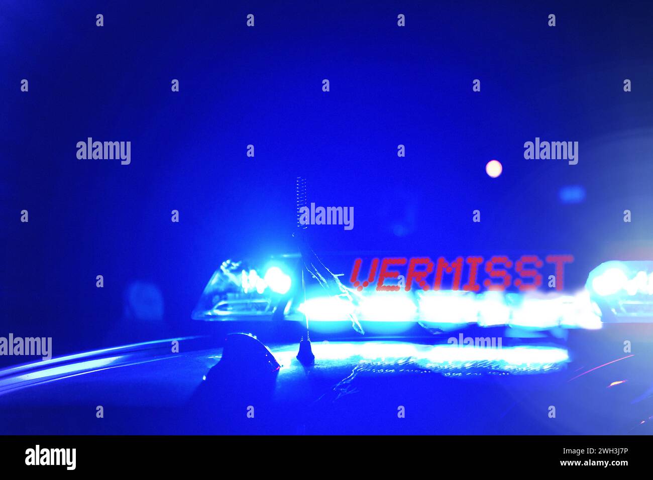 7 febbraio 2024: Pattuglia della polizia di notte, con l'iscrizione a luce blu: Missing. Immagine simbolica per la ricerca di persone e la ricerca ravvicinata. FOTOMONTAGGIO *** Streifenwagen der Polizei bei Nacht, mit der Blaulicht Aufschrift: Vermisst. Symbolbild für Personenfahndung und Nahbereichsfahndung. FOTOMONTAGE Foto Stock