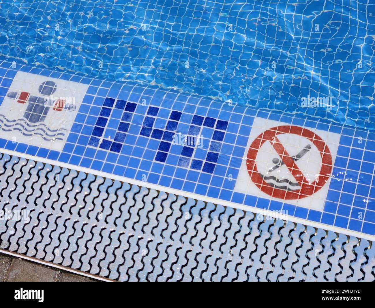 Una vista del bordo della piscina con profondità specificata per nuotare in sicurezza e un cartello di avvertimento che proibisce le immersioni. Spagna. Foto Stock