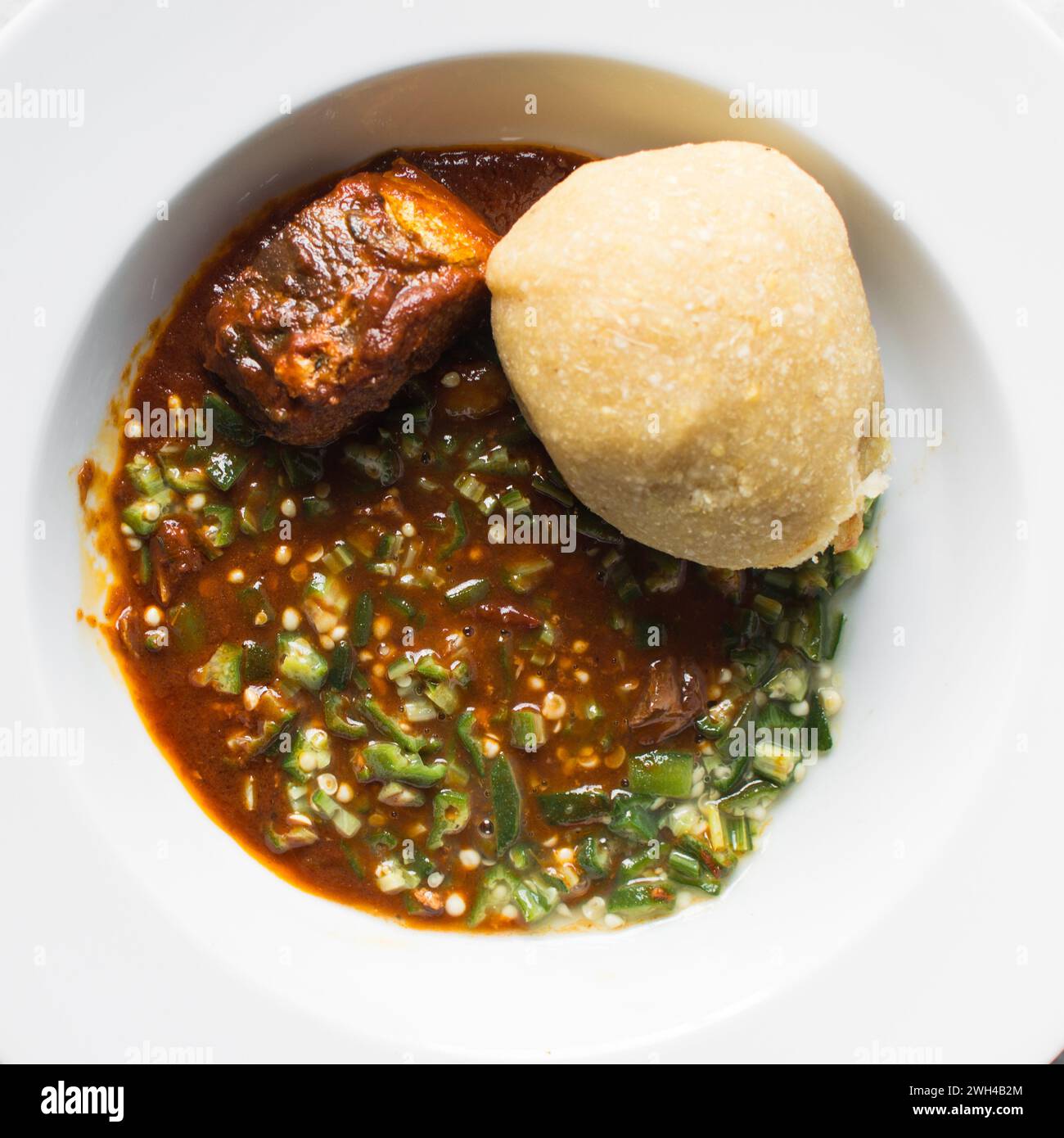 Okro nigeriano e stufato in un piatto bianco, vista dall'alto della zuppa di okro Foto Stock