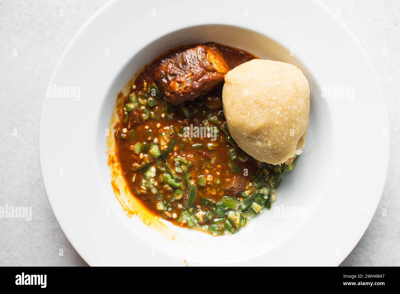 Okro nigeriano e stufato in un piatto bianco, vista dall'alto della zuppa di okro Foto Stock