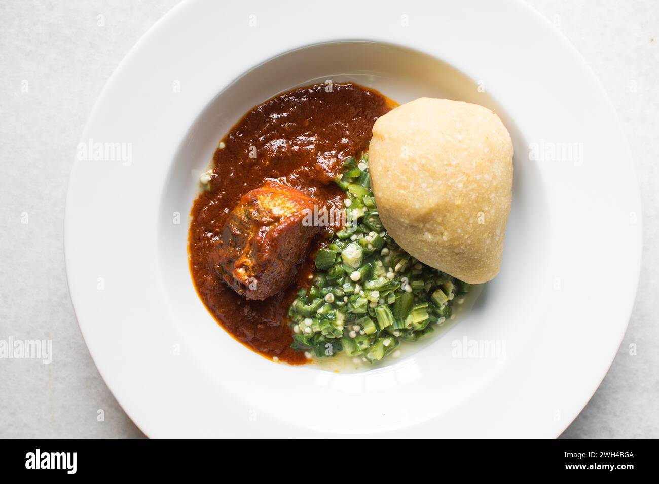 Okro nigeriano e stufato in un piatto bianco, vista dall'alto della zuppa di okro Foto Stock