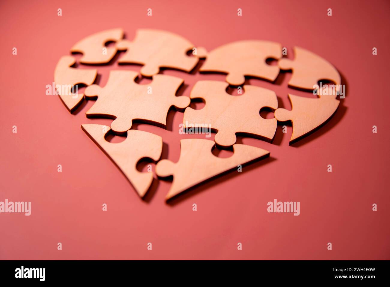 Puzzle a forma di cuore e mano umana con il pezzo mancante del puzzle. Concetto di relazioni d'amore. Foto Stock