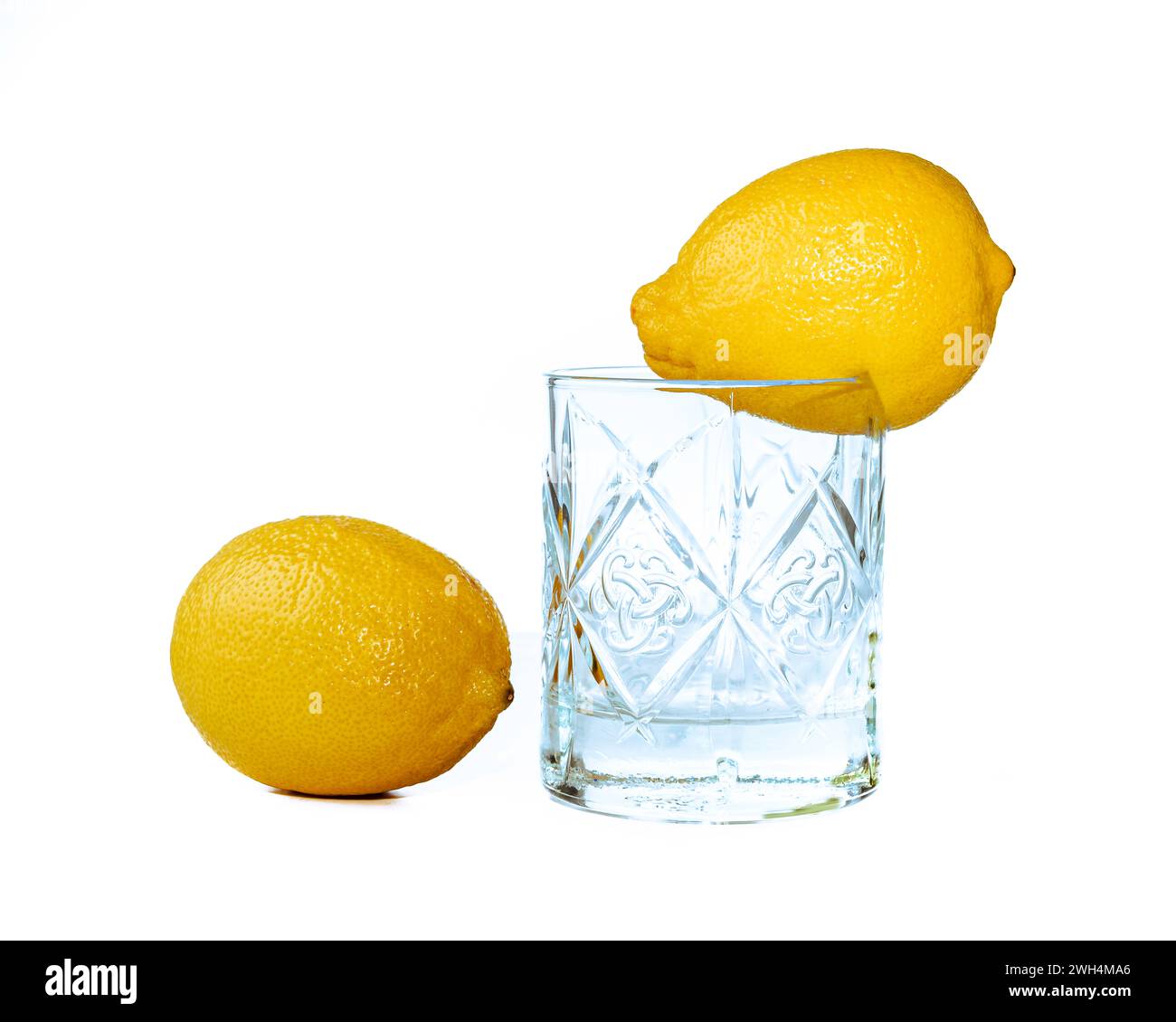 Bicchiere con limone su sfondo bianco. Proposta per la promozione di un succo di limone sano. Foto Stock