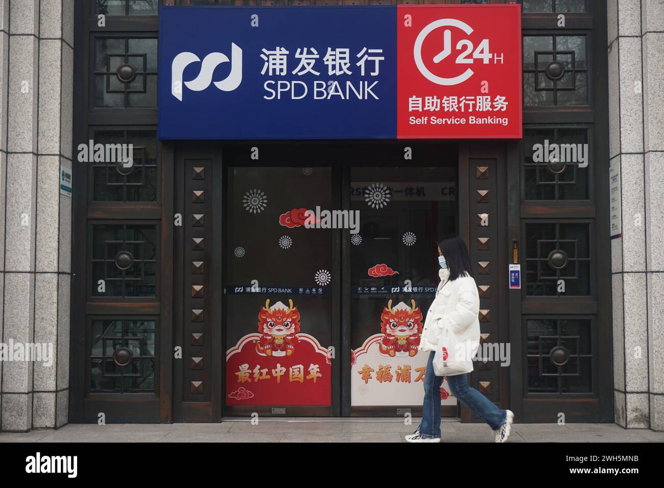 HANGZHOU, CINA - 8 FEBBRAIO 2024 - Un cittadino passa davanti al reparto vendite della Shanghai Pudong Development Bank a Hangzhou, nella zona orientale dello Zhejiang della Cina Foto Stock