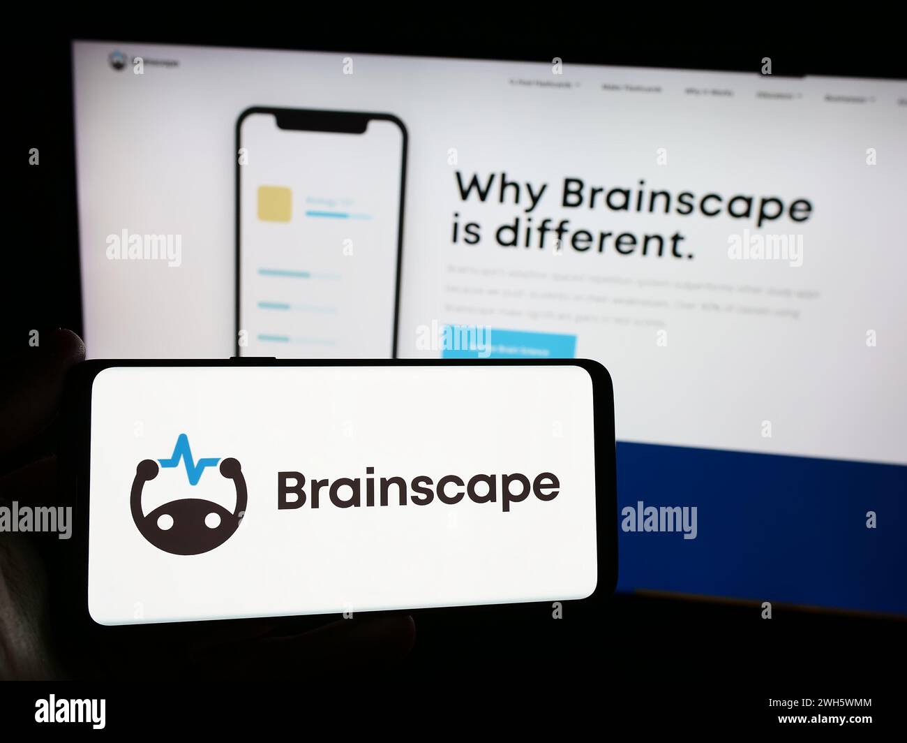 Persona che possiede uno smartphone con il logo della società statunitense di piattaforme educative online Brainscape davanti al sito Web. Mettere a fuoco il display del telefono. Foto Stock