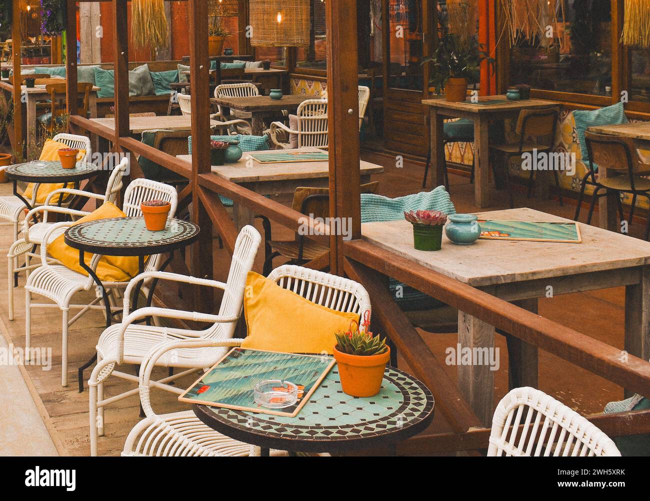 Un caffè all'aperto con tavoli e panchine in legno rustico per una comoda cena all'aperto Foto Stock