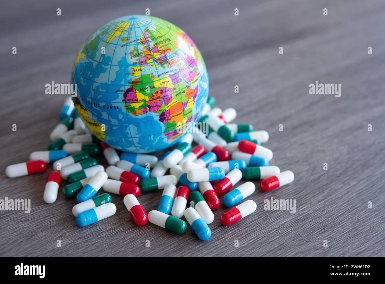 Colorata pila di pillole medicinali e globo. Copia spazio per il testo. Concetto medico e sanitario. Foto Stock