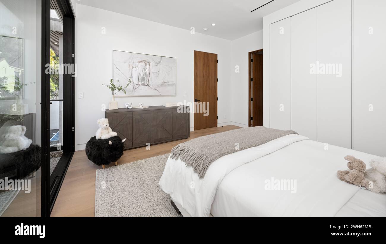 Una camera accogliente con un comodo letto e un elegante comò Foto Stock