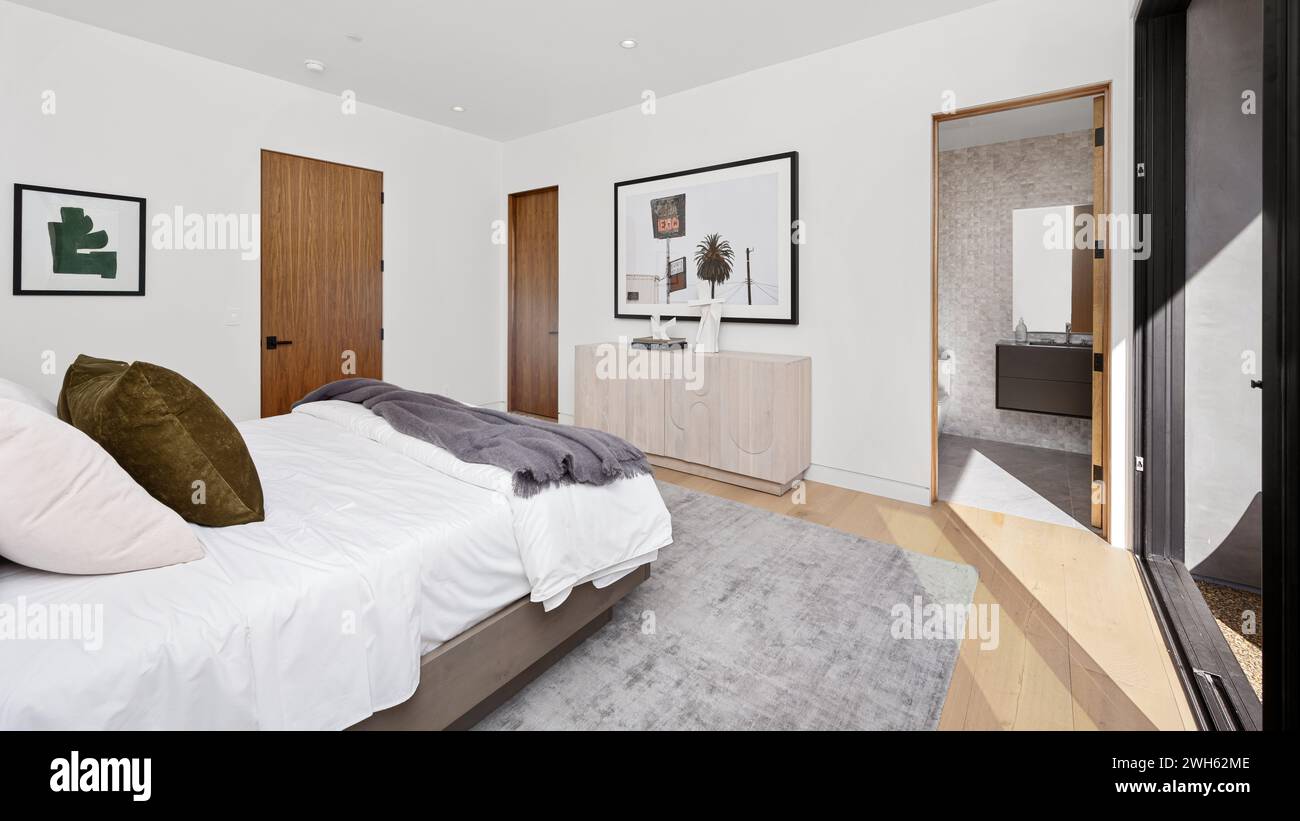 Una camera accogliente con un comodo letto e un elegante comò Foto Stock