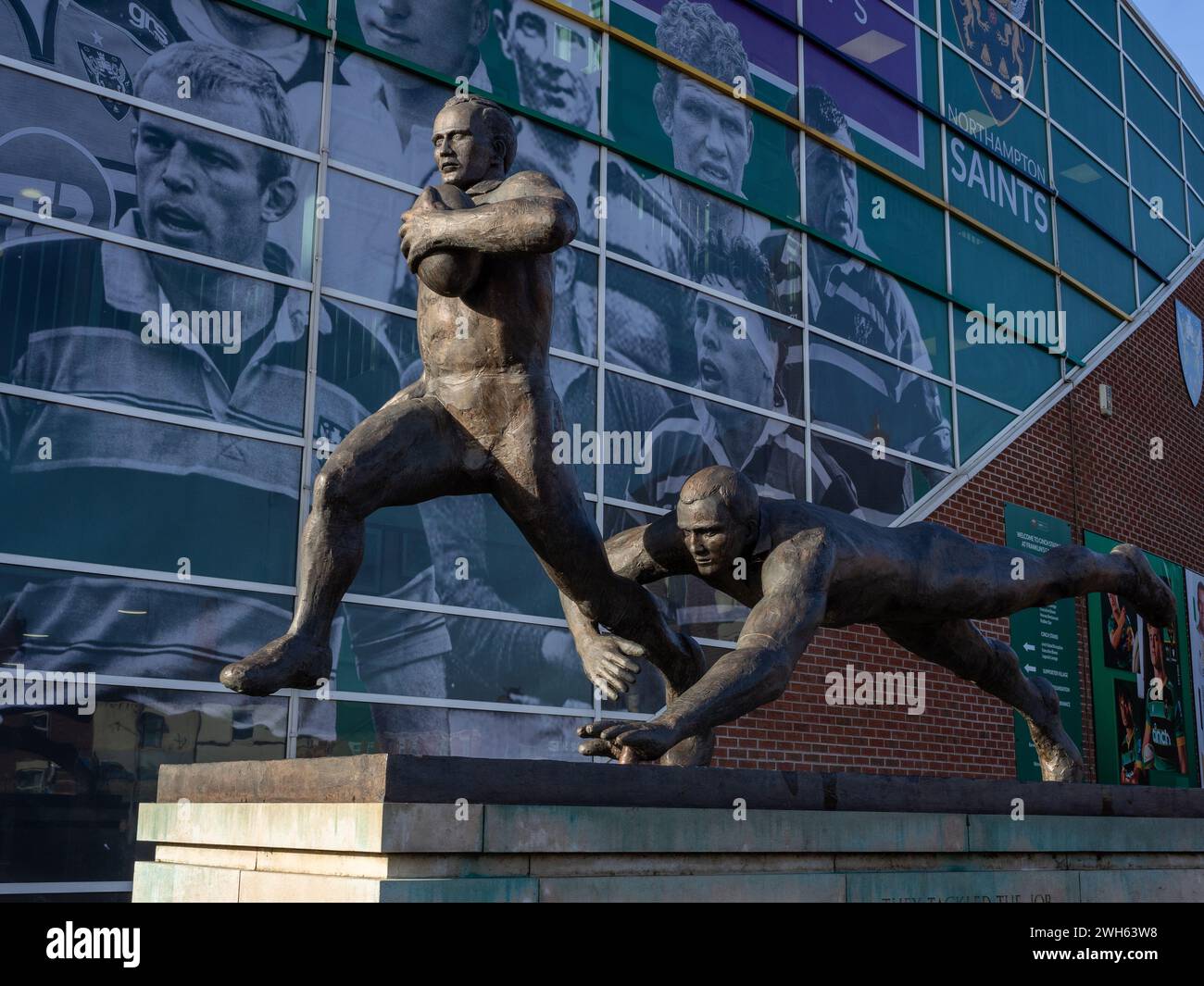 Affrontarono The Job, una scultura in bronzo, all'ingresso dei Franklins Gardens, sede del Northampton Saints Rugby Club, Northampton, Regno Unito Foto Stock