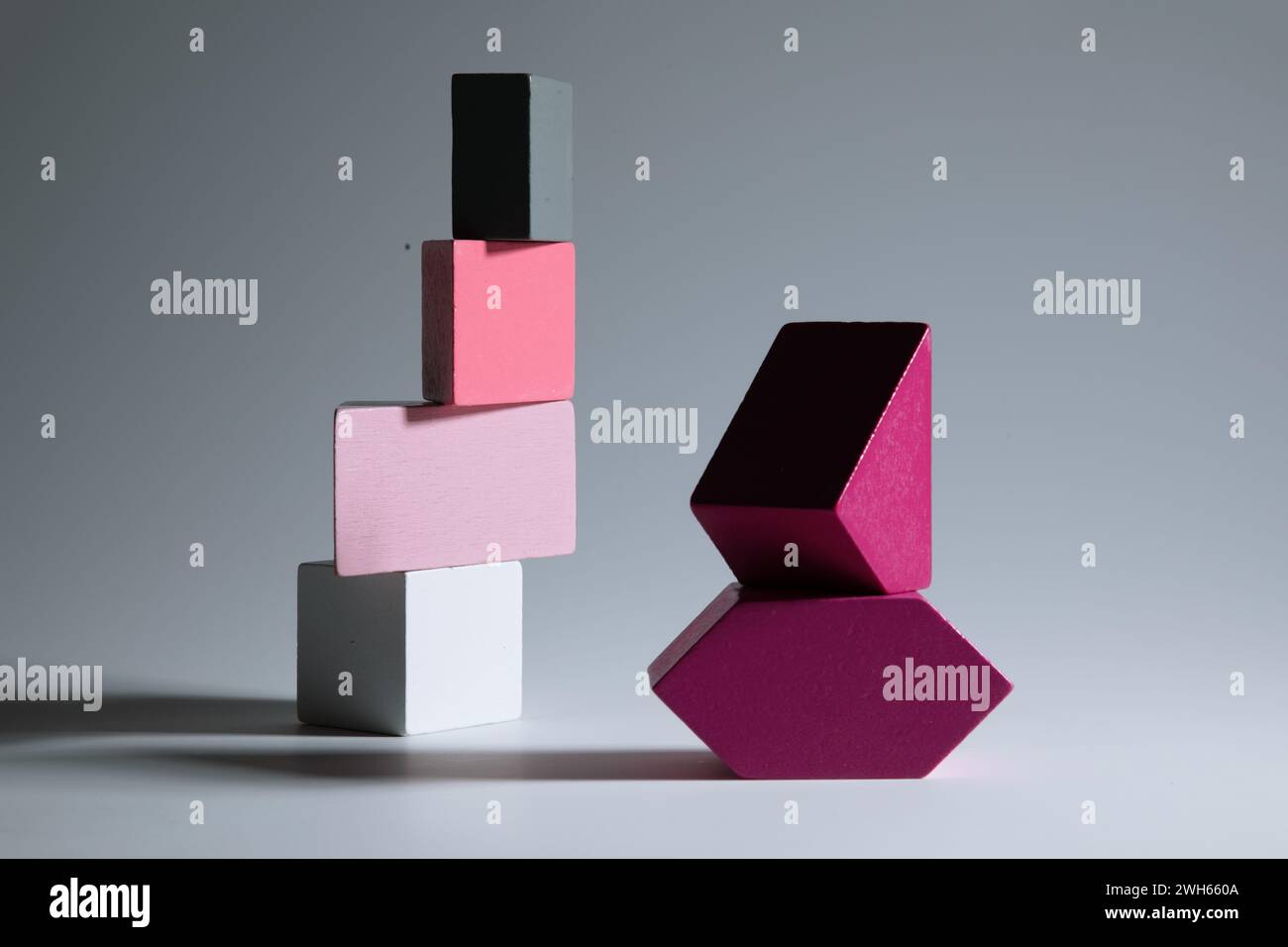 Blocchi di giocattoli rosa e grigi su sfondo grigio Foto Stock