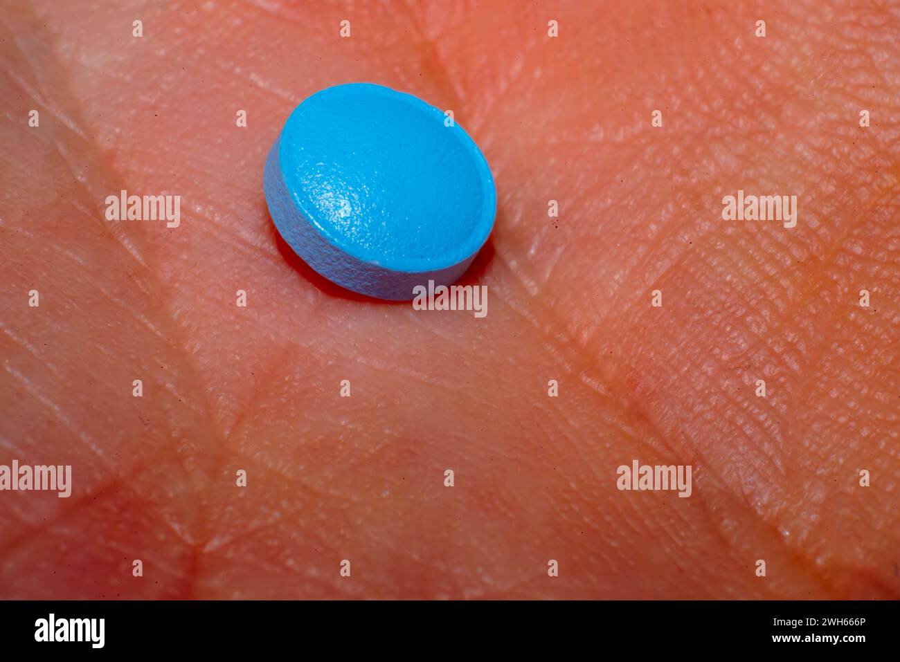 Una foto macro di primo piano che cattura i dettagli intricati di una pillola blu, che rappresenta l'assistenza farmaceutica per la salute e il benessere Foto Stock