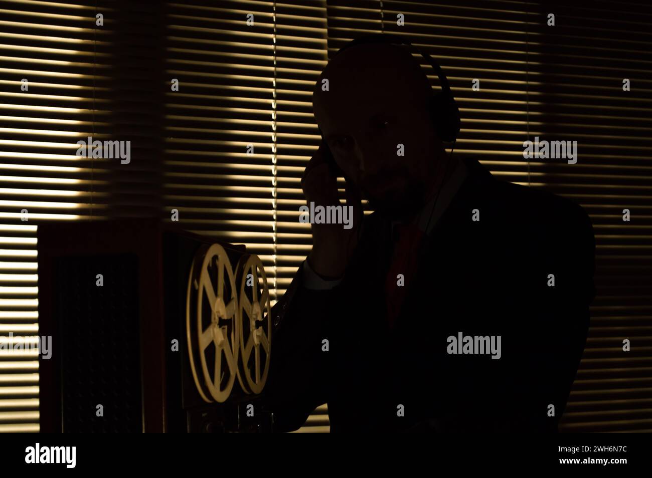 Un agente segreto registra il suono su un registratore a nastro bobina, tono scuro. Foto Stock