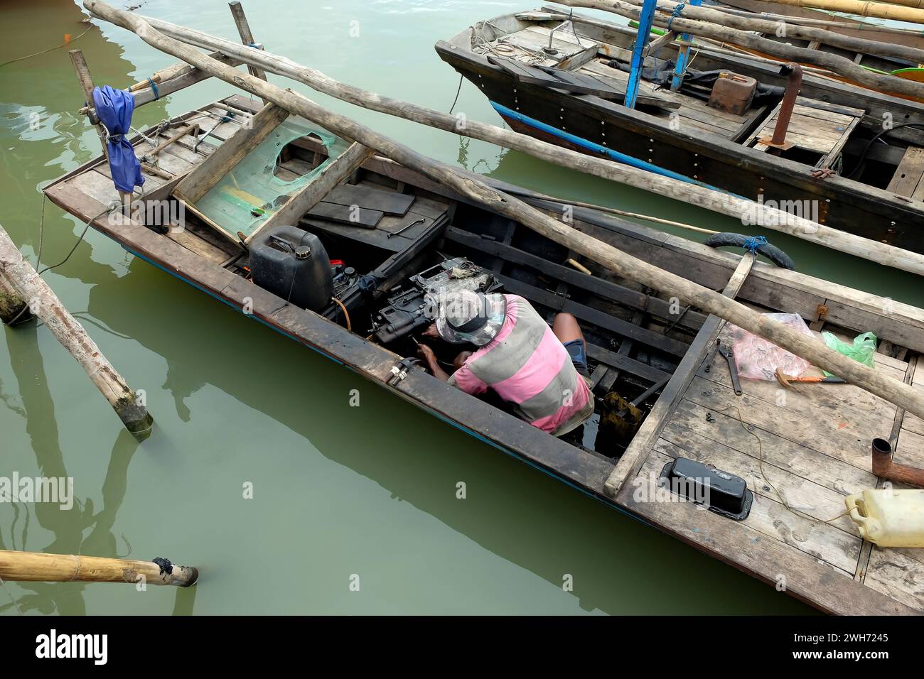 Pescatori che riparano un motore di una barca rotto Foto Stock