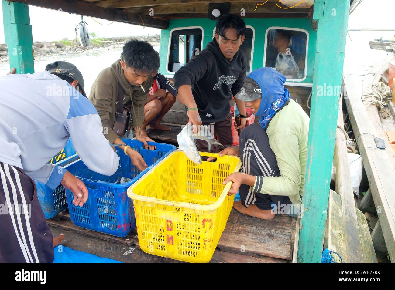 Lampung, Indonesia, 7 ottobre 2022: I pescatori o i membri dell'equipaggio selezionano il pesce in un cesto che è stato appena catturato e sarà pesato. Foto Stock