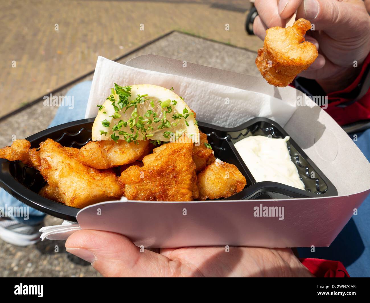 Kibbeling, un popolare spuntino olandese a base di pepite fritte servite con una fetta di limone e maionese su un vassoio di cartone, Paesi Bassi Foto Stock