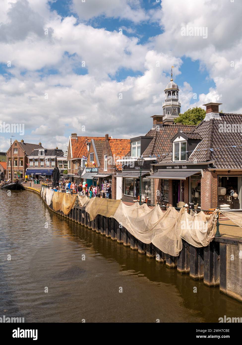 La banchina di Oudesluis lungo il canale Het Dok con negozi in vecchi edifici, Lemmer, Frisia, Paesi Bassi Foto Stock