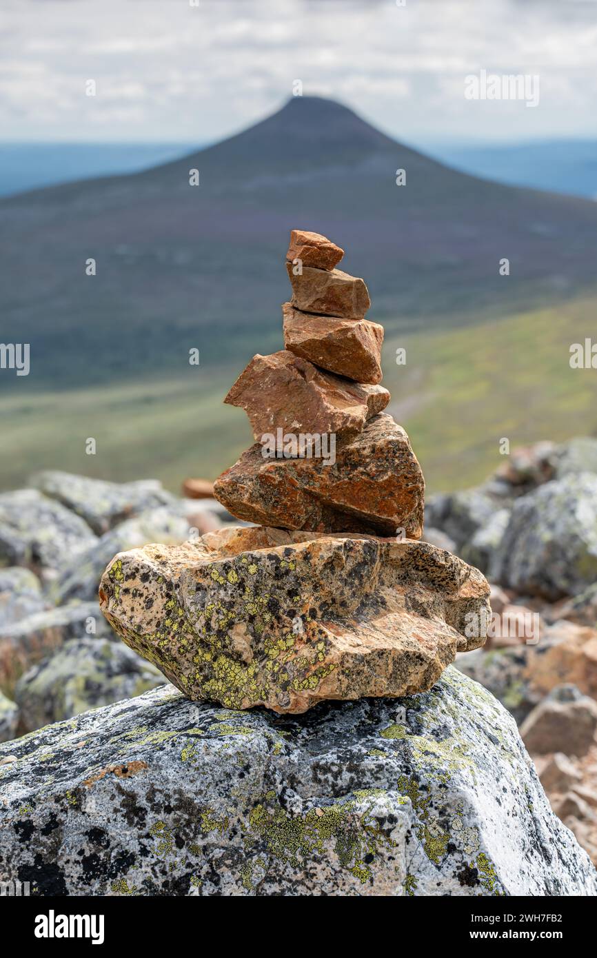 Sulla cima del monte Nipfjället, pietre impilate formano un cairn o piramide costruito dai turisti in estate, con il monte Städjan sullo sfondo. Dalarna Svezia Foto Stock