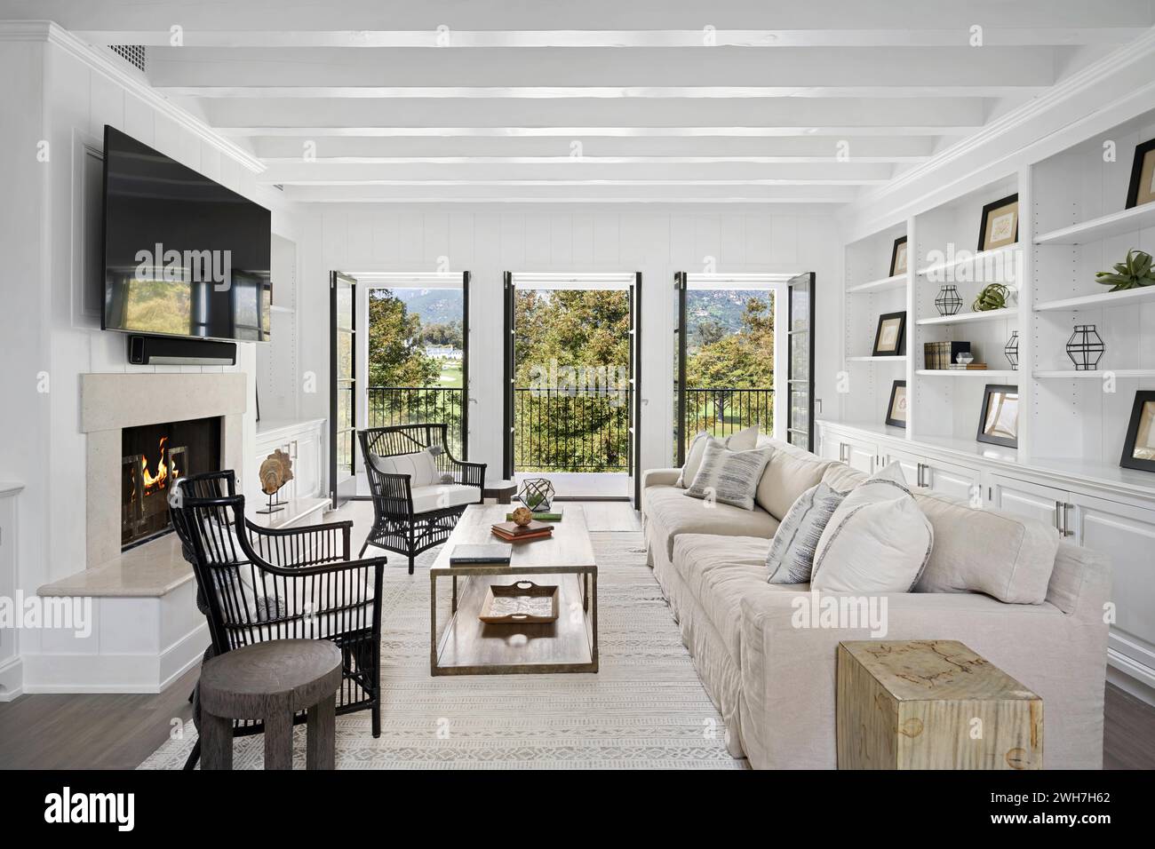 Alcuni divani bianchi e ampie finestre in un soggiorno ben arredato Foto Stock