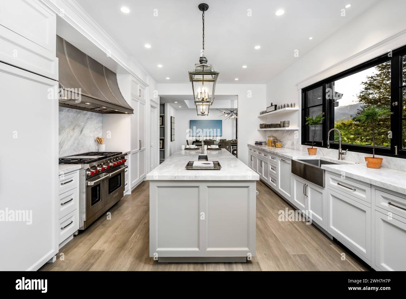 Una spaziosa cucina con pavimenti in legno duro e un'ampia isola centrale Foto Stock