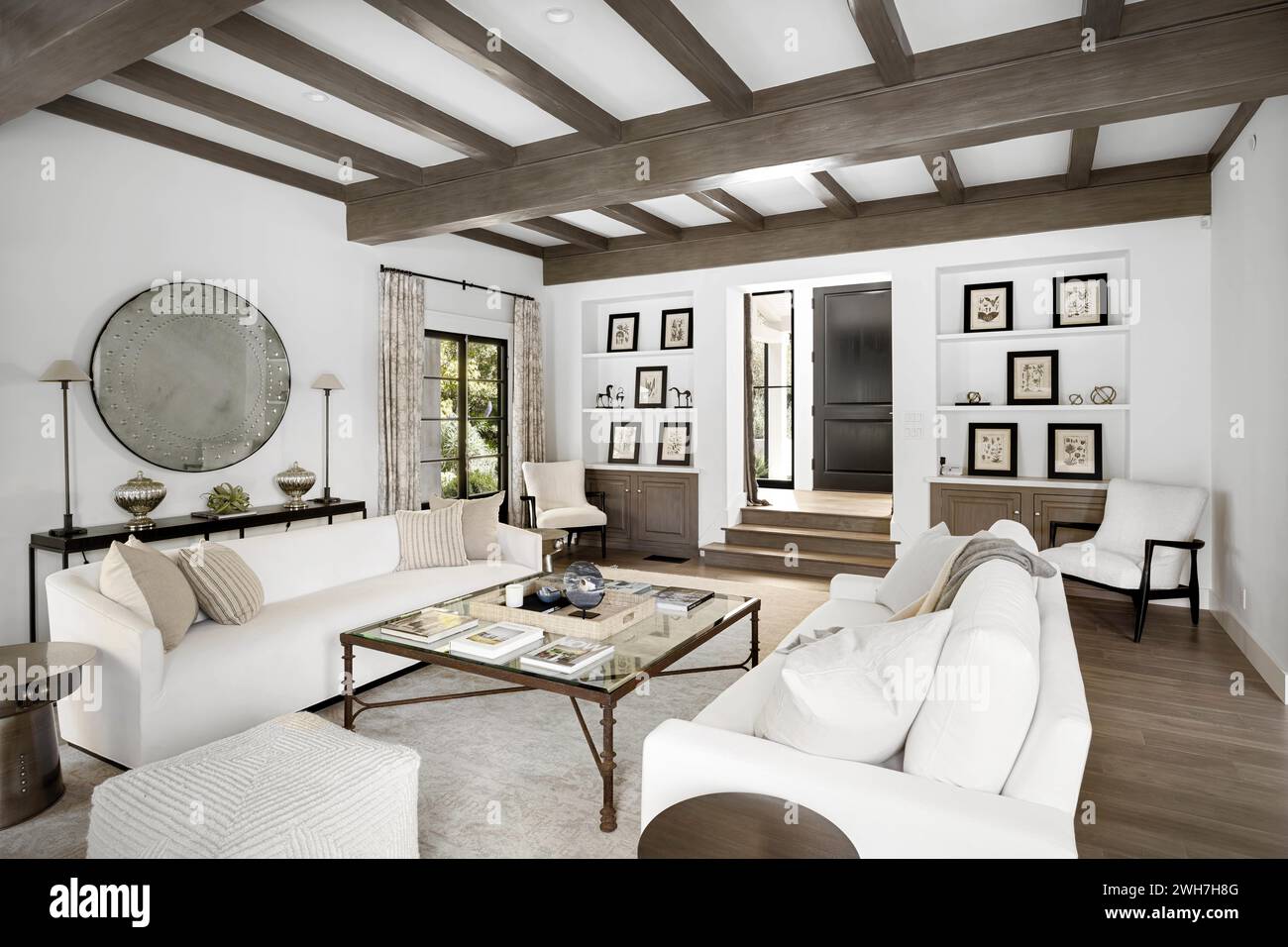 Un moderno soggiorno bianco con spaziose aree salotto dotate di grandi divani e sedie bianche Foto Stock