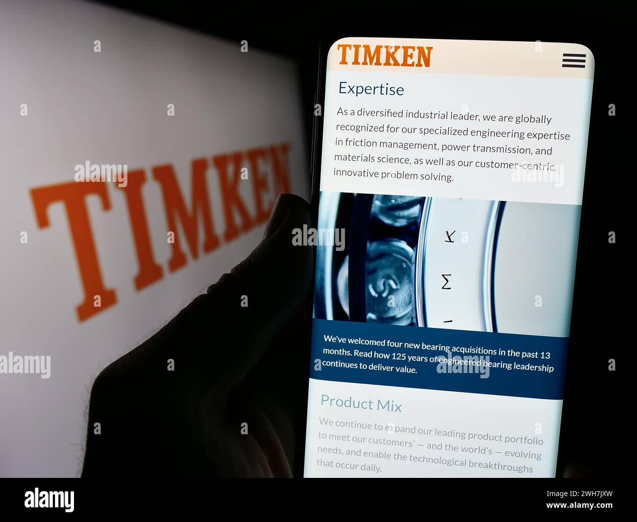 Persona che detiene un cellulare con il sito Web della società di produzione di cuscinetti degli Stati Uniti The Timken Company davanti al logo. Messa a fuoco al centro del display del telefono. Foto Stock