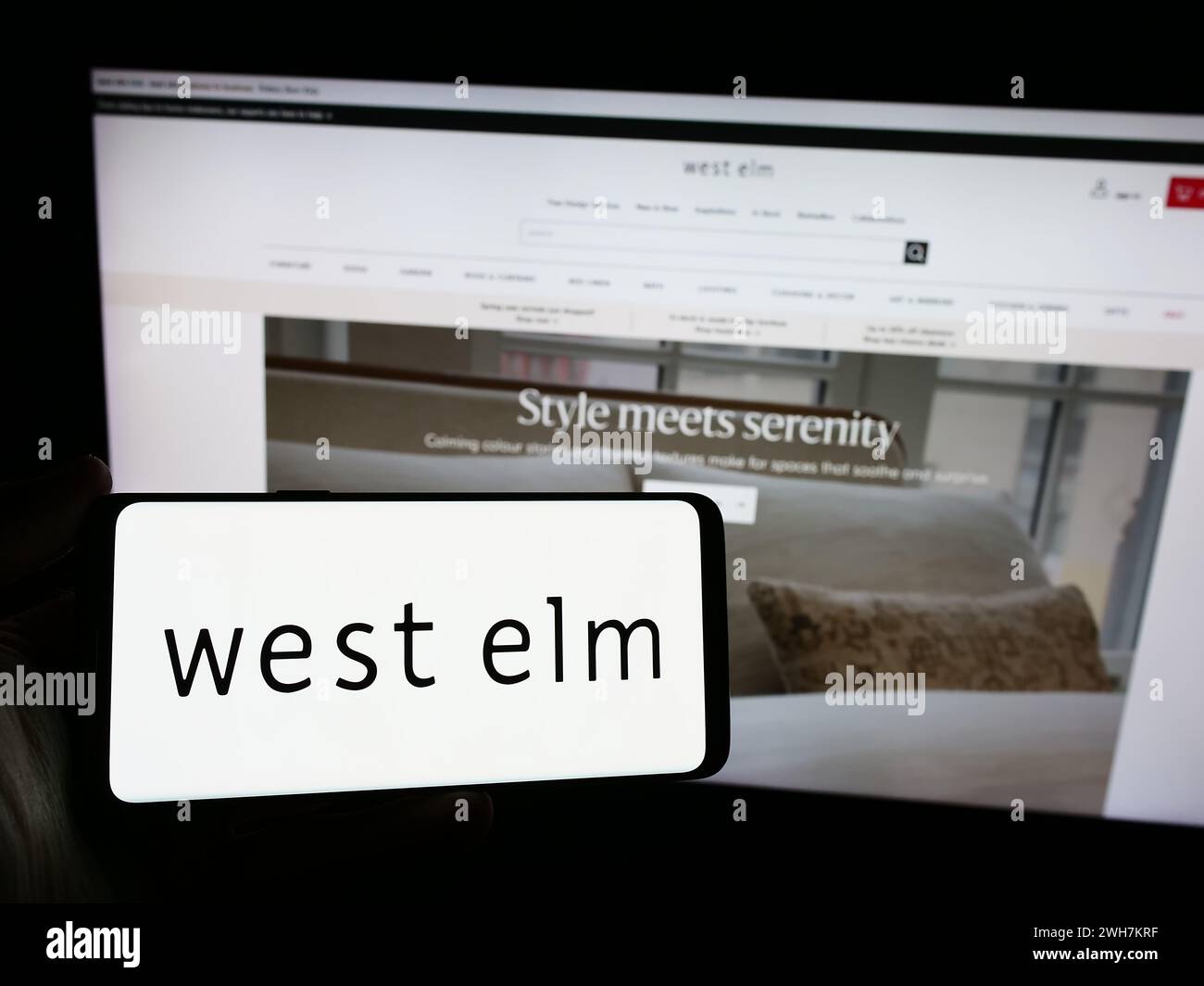 Persona con smartphone con logo dell'azienda di arredamento West Elm davanti al sito Web. Mettere a fuoco il display del telefono. Foto Stock