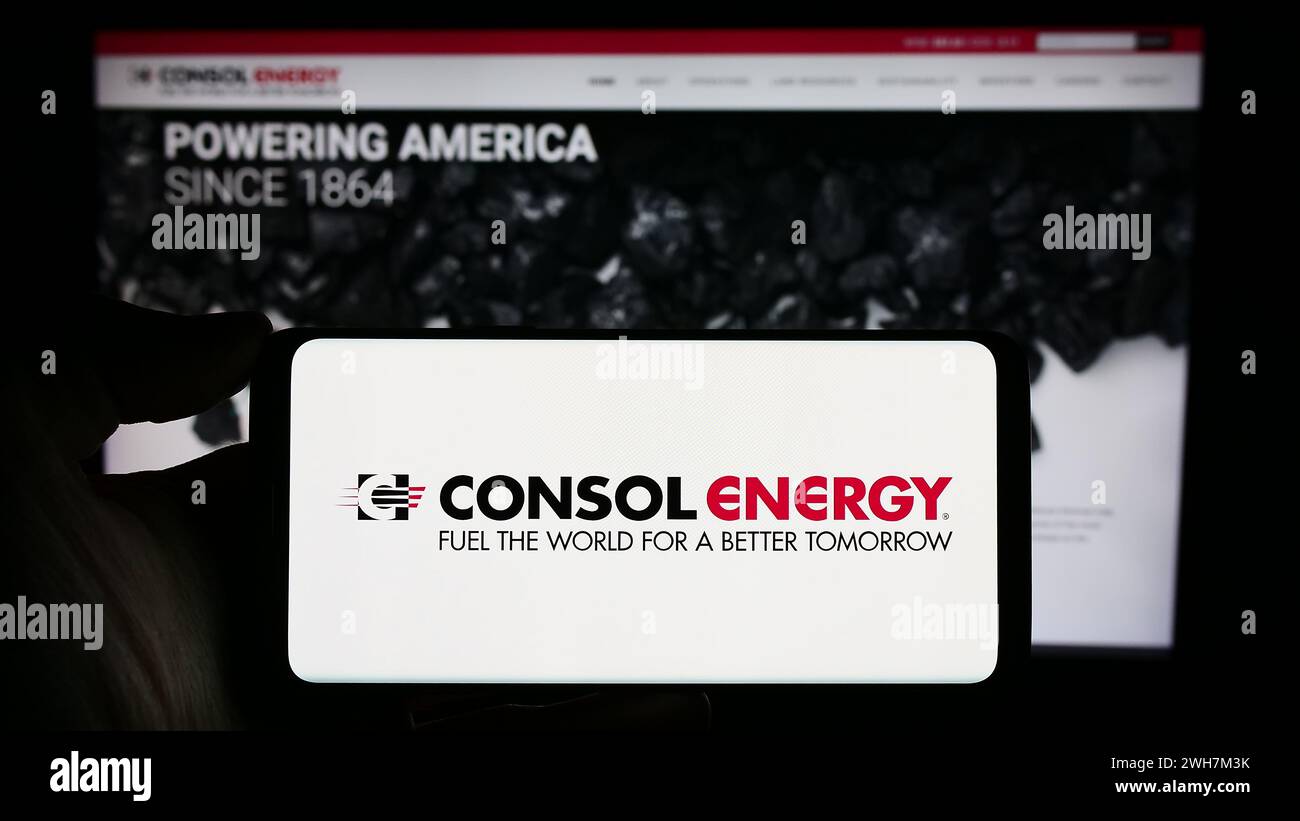 Persona che detiene un cellulare con il logo della società mineraria statunitense CONSOL Energy Inc. Di fronte alla pagina Web aziendale. Mettere a fuoco il display del telefono. Foto Stock