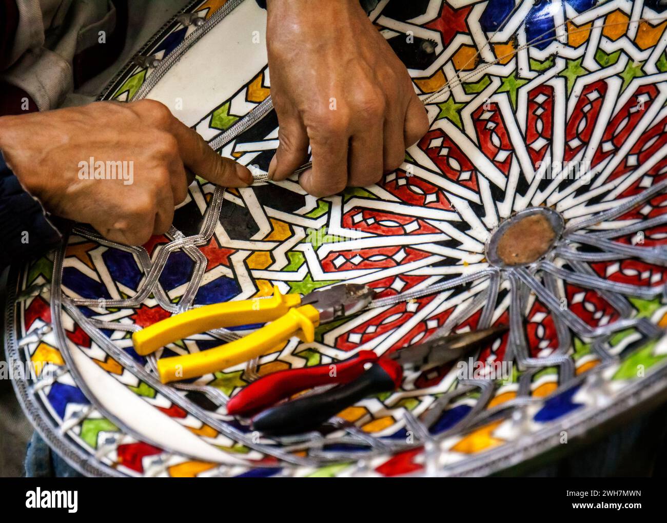 Artigiano marocchino che infila un mosaico su una tradizionale ciotola fatta a mano in vendita sul mercato Foto Stock