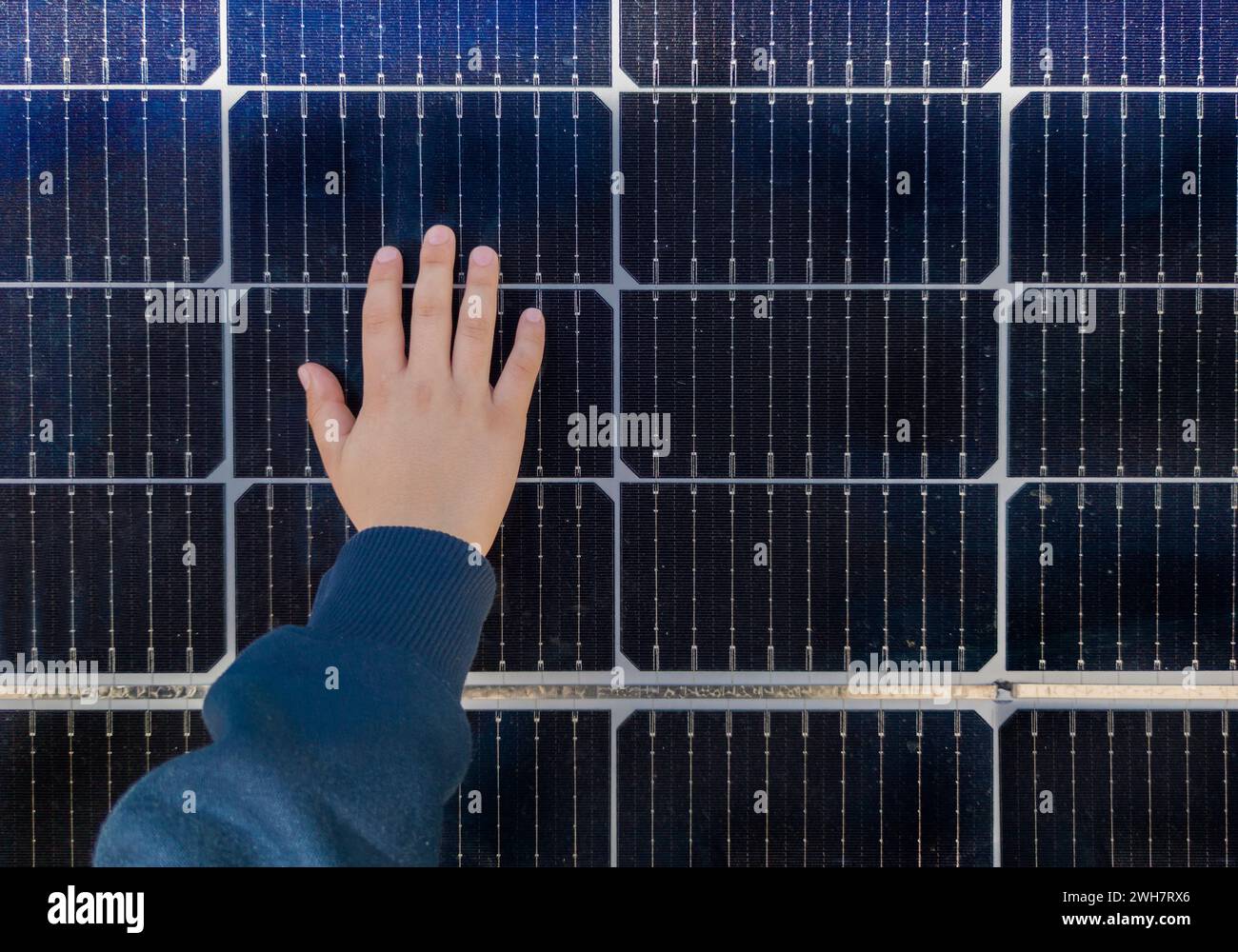 Bambino che tocca la superficie del pannello solare. Educazione ambientale alle energie rinnovabili Foto Stock