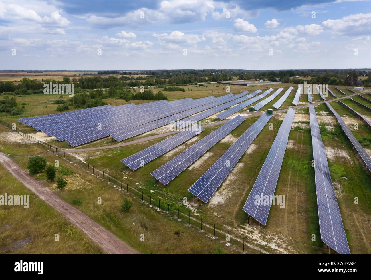 Stazione a batteria solare. Vista droni dei pannelli solari. Tipi di energia alternativi. Vista laterale dei pannelli solari sullo sfondo blu del cielo. Foto Stock