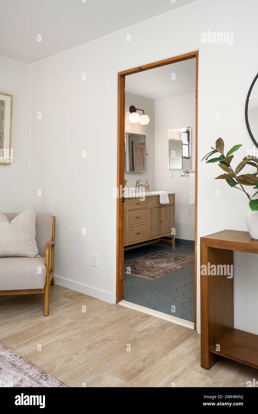 Accogliente soggiorno decorato con mobili eleganti, caratterizzato da pareti e pavimenti bianchi immacolati Foto Stock