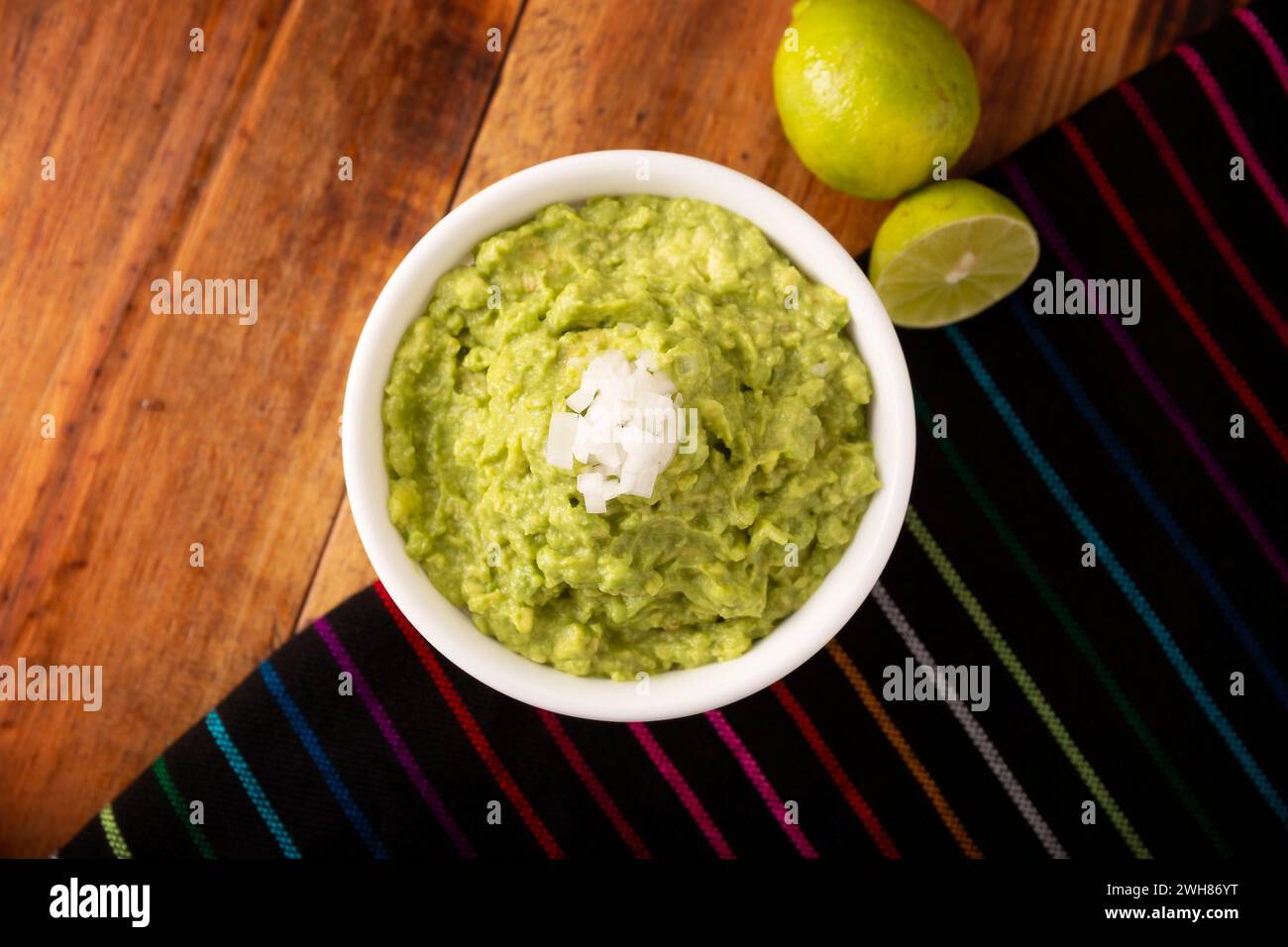Guacamole. La salsa all'avocado, uno dei suoi molti modi di consumarla, è sparsa su patatine di tortilla chiamate anche Nachos. Ricetta messicana con salsa casereccia semplice Foto Stock