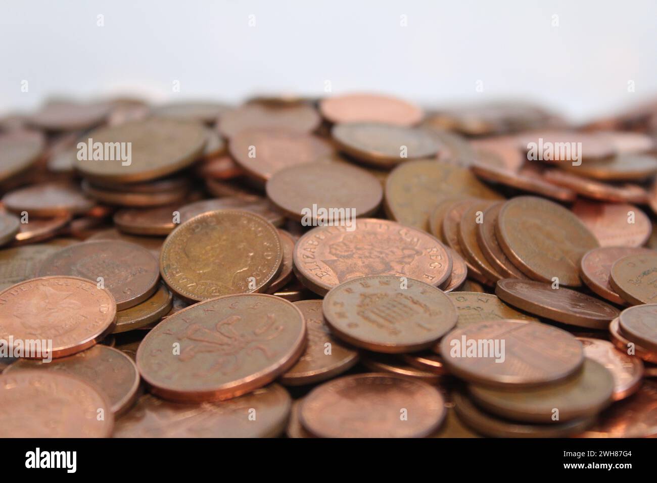 Le monete da uno e due pence britanniche si diffondono contro un fondo bianco Foto Stock