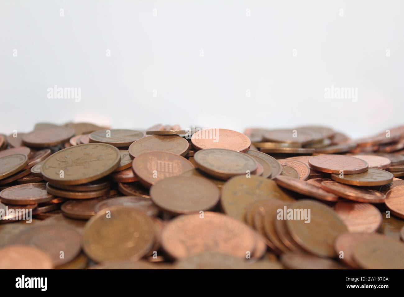 Le monete da uno e due pence britanniche si diffondono contro un fondo bianco Foto Stock
