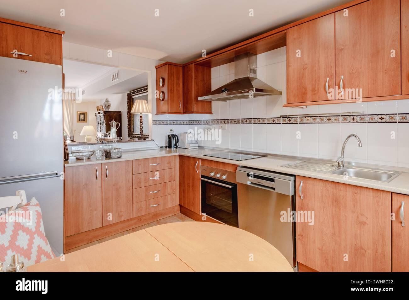 una cucina a vista con armadi in legno con portello di servizio nell'appartamento per le vacanze Foto Stock