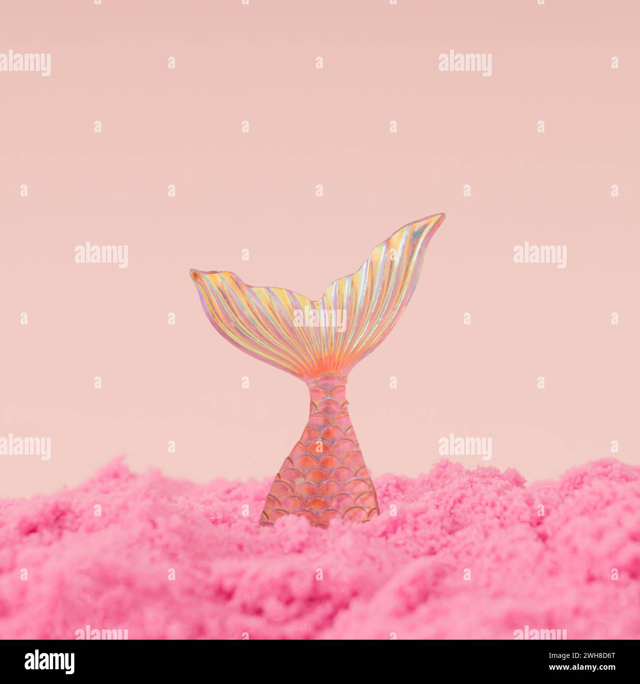 Layout creativo e alla moda realizzato con sirena che si tuffa nella sabbia rosa su uno sfondo rosa piccante. Concetto estivo minimalista. Un'idea magica per una spiaggia estiva Foto Stock