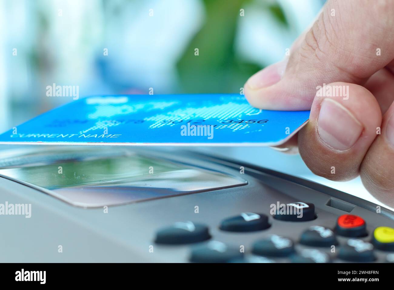 Uomo d'affari con carta di credito blu con tecnologia nfc. Moneta elettronica e concetto di pagamento. Primo piano Foto Stock