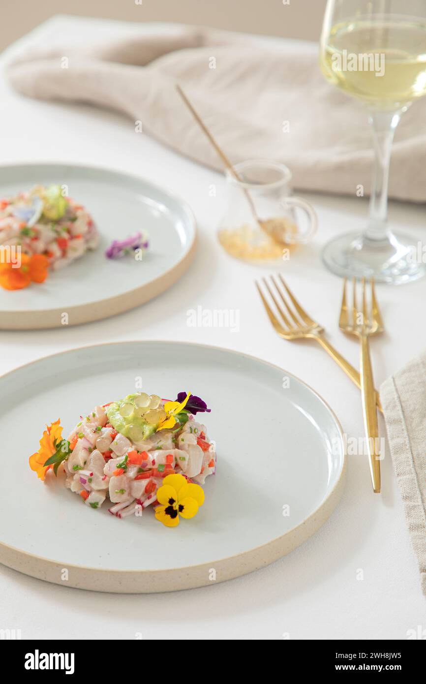 Kingfish Tartare servito con fiori commestibili in un ristorante Foto Stock