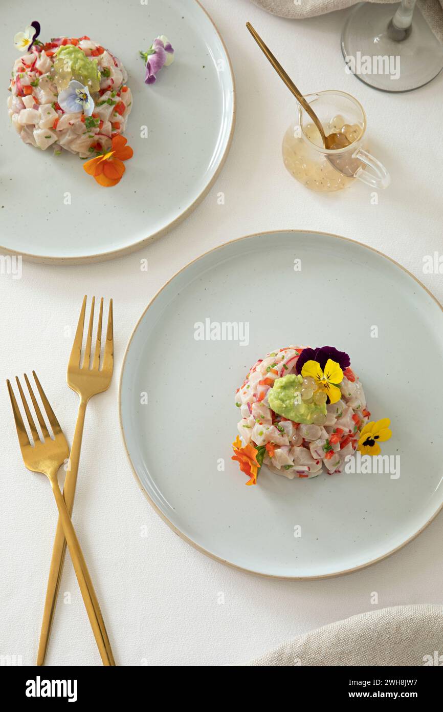 Kingfish Tartare servito con fiori commestibili in un ristorante Foto Stock