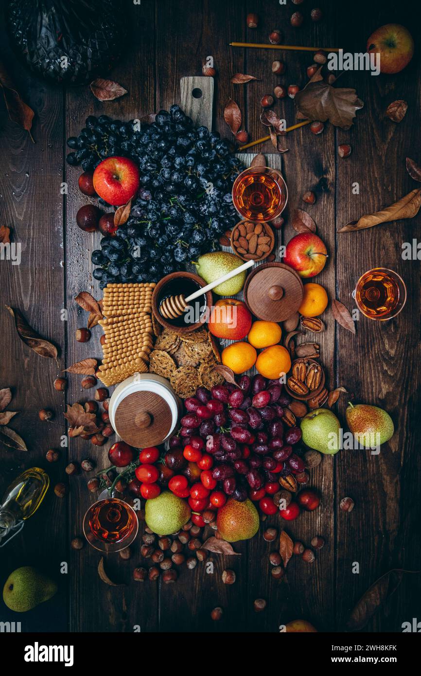 Chesse board vegana con frutta fresca e biscotti salati su un tavolo di legno Foto Stock