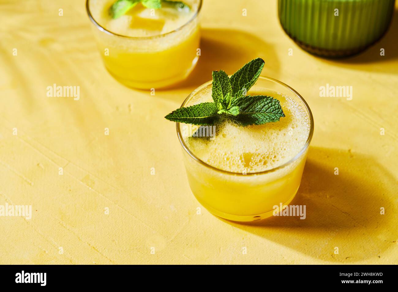 Ananas menta G&TS con pourer su sfondo giallo con ombra Foto Stock