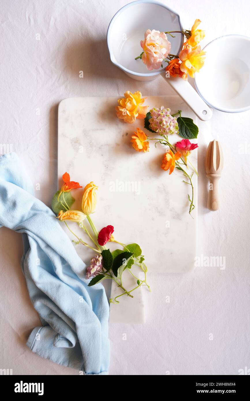 Cucinare con fiori commestibili preparazione alimentare concetto creativo flatlay. Foto Stock
