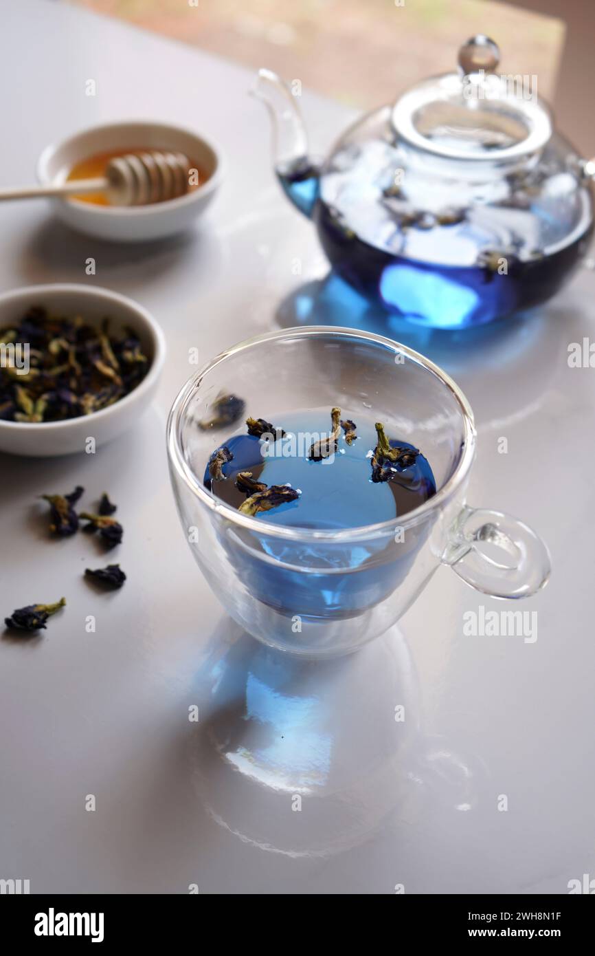 Tè blu al fiore di pisello con teiera in vetro e primo piano della tazza. Foto Stock