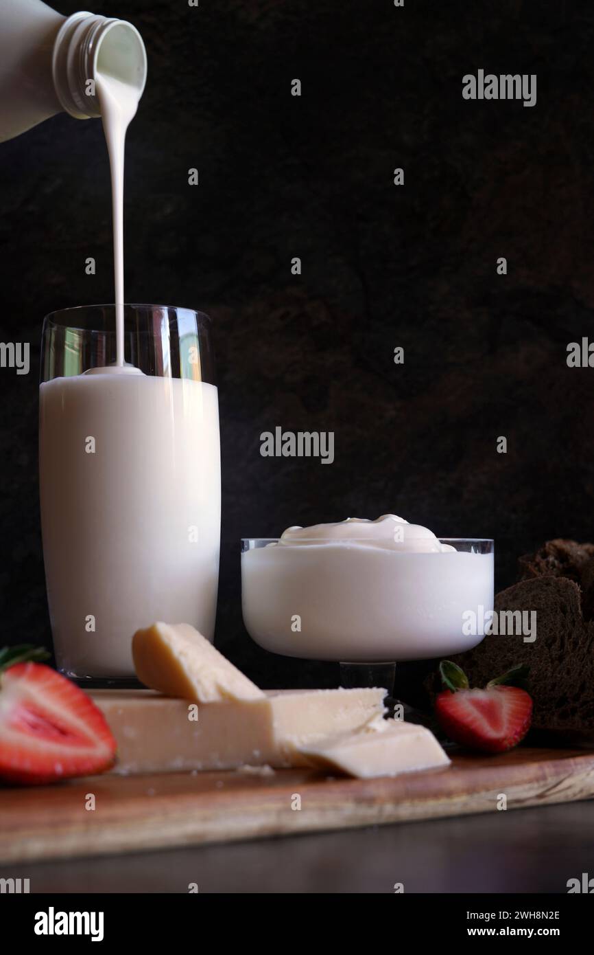 Sano caseificio probiotico, tra cui kefir, yogurt greco e parmgiano reggiano. Versare kefir dal flacone. Foto Stock
