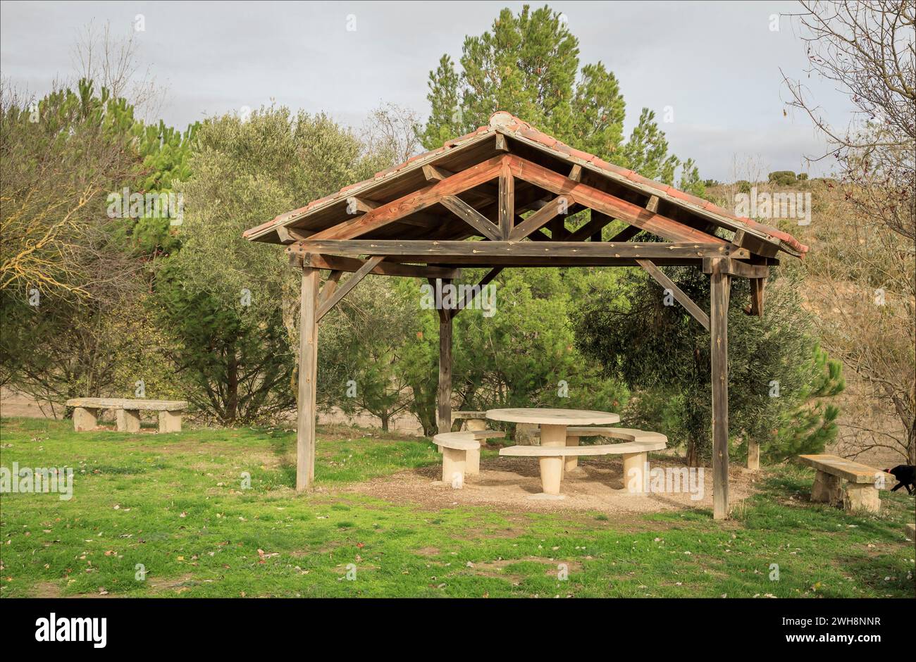 Pagoda all'aperto in un'area picnic per tenere lontano il sole con tavoli e panchine in cemento Foto Stock