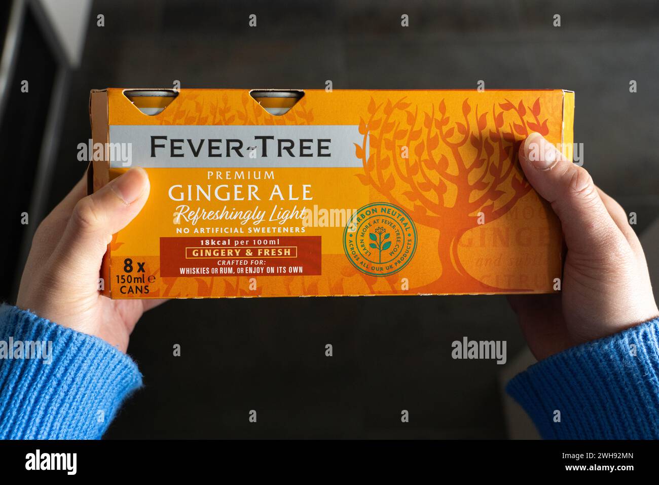 Una donna che tiene in mano una scatola di lattine di ginger ale premium Fever-Tree. Miscele di bevande premium di Fevertree Limited, una società britannica di bevande analcoliche. REGNO UNITO Foto Stock