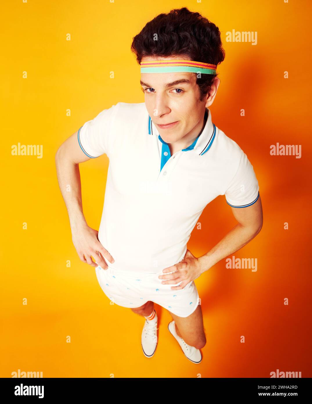 Studio, ritratto e uomo in uniforme da tennis retrò con sicurezza, sorriso e angolazione alta. Palestra, club e atleta felice in stile vintage Foto Stock